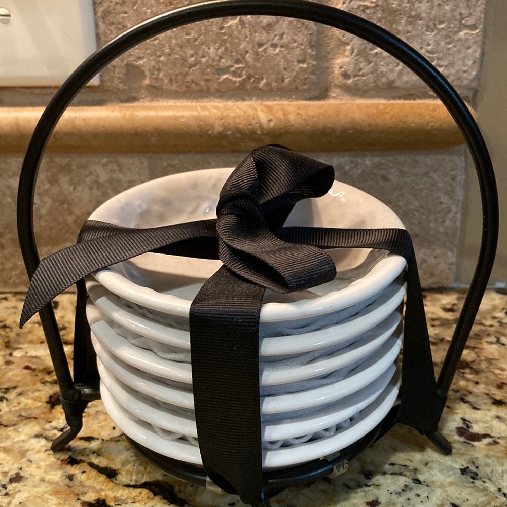 Signature set of small plates in a metal rack. Stoneware.